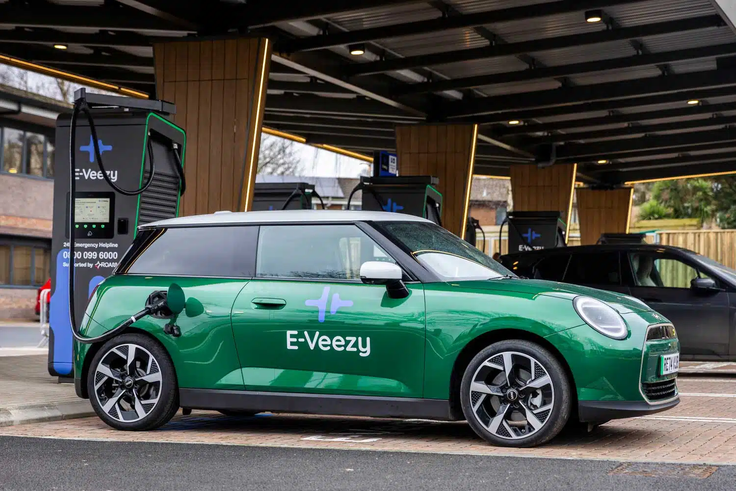 E‑Veezy electric vehicle charging station with digital interface, contactless payment, and emergency helpline.
