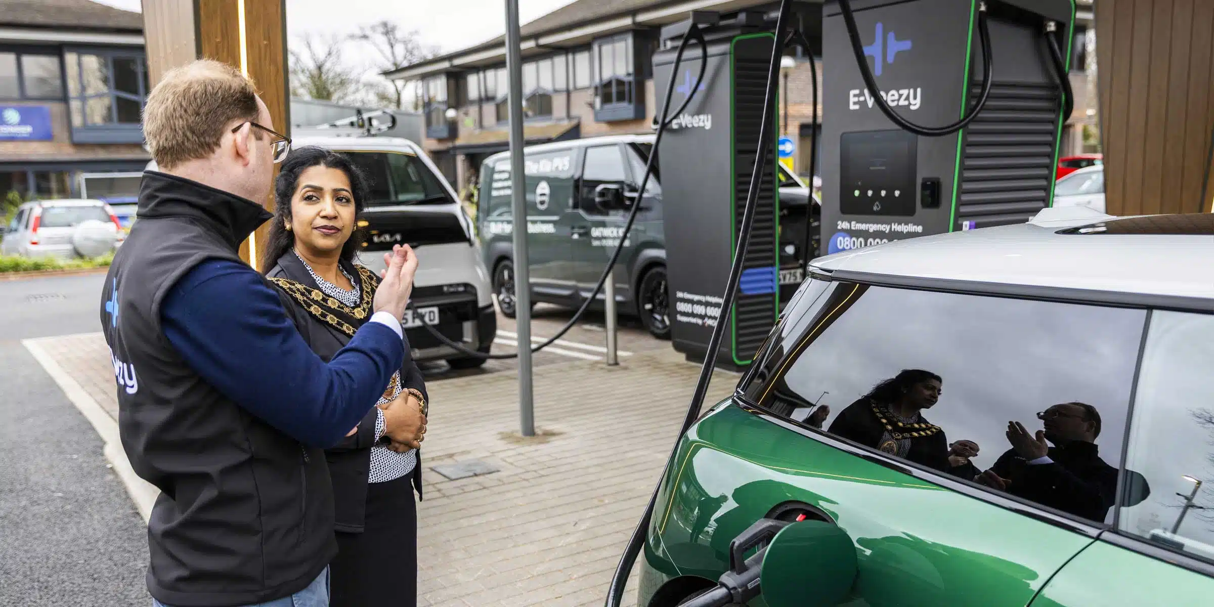 Solar-powered EV charging station with multiple electric vehicles and landscaped urban design, supporting clean mobility.