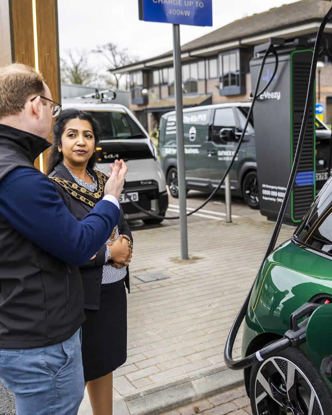 Solar-powered EV charging station with multiple electric vehicles and landscaped urban design, supporting clean mobility.